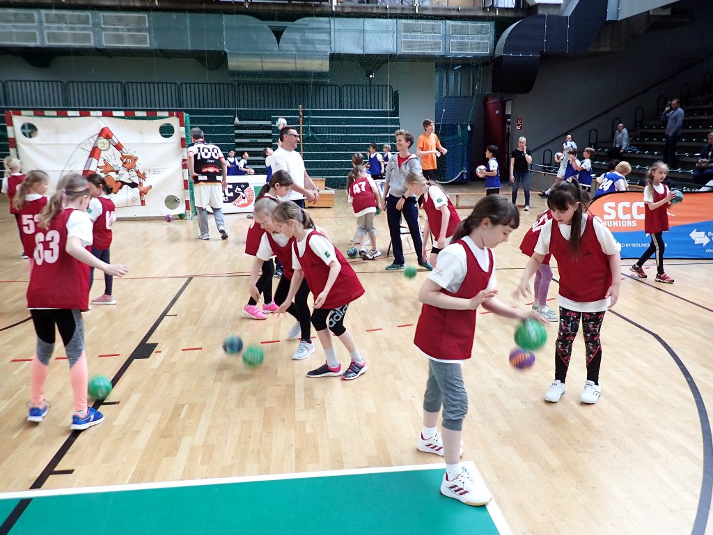 Kinder prellen einen Handball