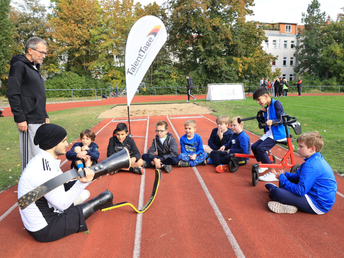 Para-Sportler Ali Lacin im Gespräch mit den sportbegeisterten Kindern